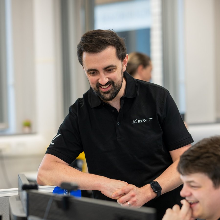 An EPX IT engineer talking through a piece of work with a colleague in the Stafford office